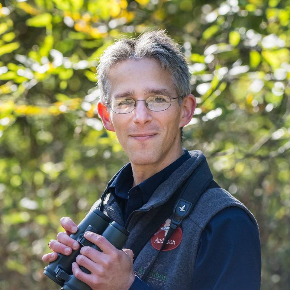 Dan Scheiman wears an Audubon branded fleece vest and binoculars around his neck.